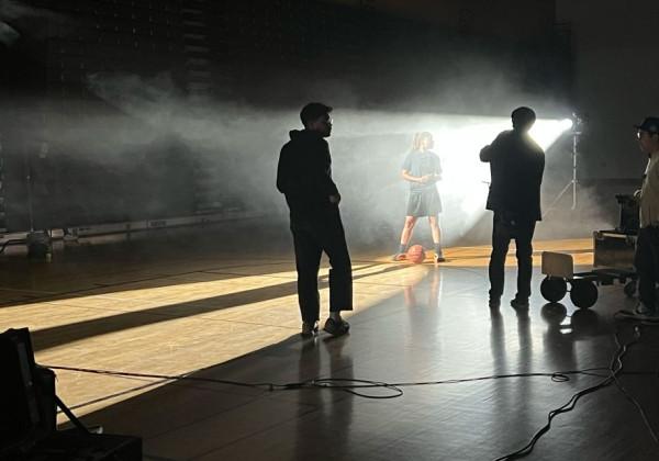 Students filming in an atmospheric gym setting.